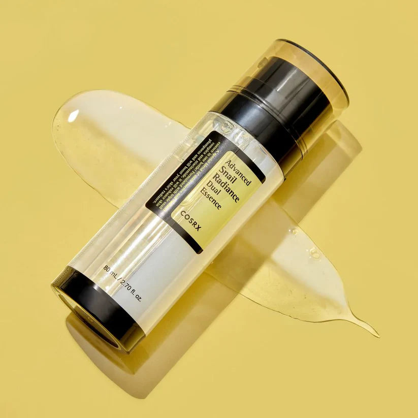 COSRX Advanced Snail Radiance Dual Essence - Model Holding Two Bottles