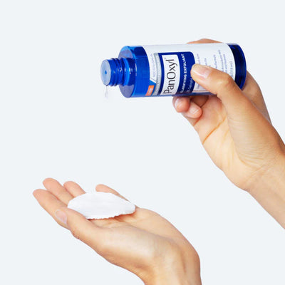 PanOxyl Clarifying Exfoliant - Pouring onto Hand Showing Lightweight Liquid Texture