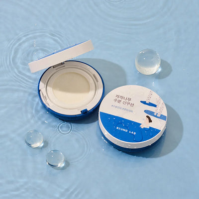 Round Lab Birch Juice Moisture Sun Cushion - Open Compact with Water Droplets on Blue Background
